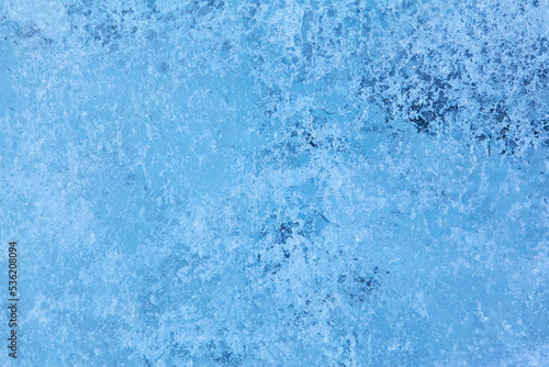 Texture of winter ice surface. Blue natural ice background