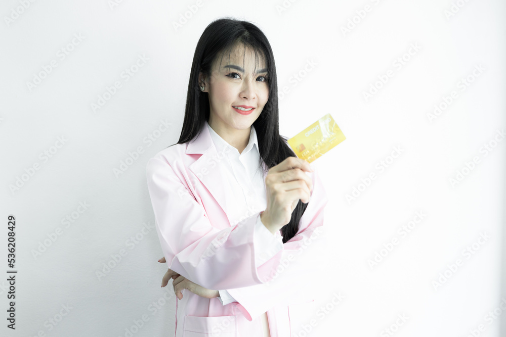 Beautiful Asian woman doctor showing and presenting bank business credit card with copy space on white background, Asian woman doctor in uniform pink coat with credit card, Medical and healthcare. Beautiful Asian woman doctor showing and presenting bank business credit card with copy space on white background, Asian woman doctor in uniform pink coat with credit card, Medical and healthcare.