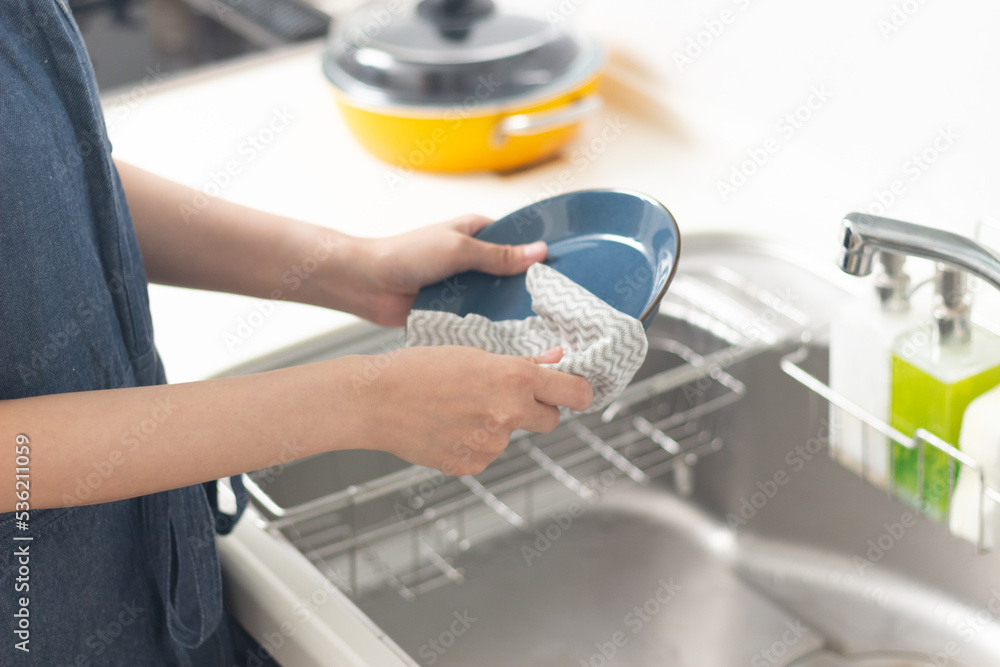 皿拭きをする女性の手元