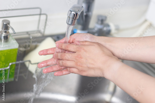 キッチンのシンクで手を洗う女性の手元