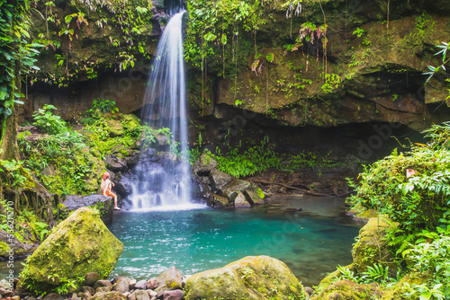 A swimmer enjoying Emerald Pool in the lush rain forest, the waterfall is a beautiful jewel of Dominica in the Caribbean