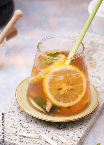 Glass of fresh lemon ice tea with lemongrass on white marble table. Selective Focus