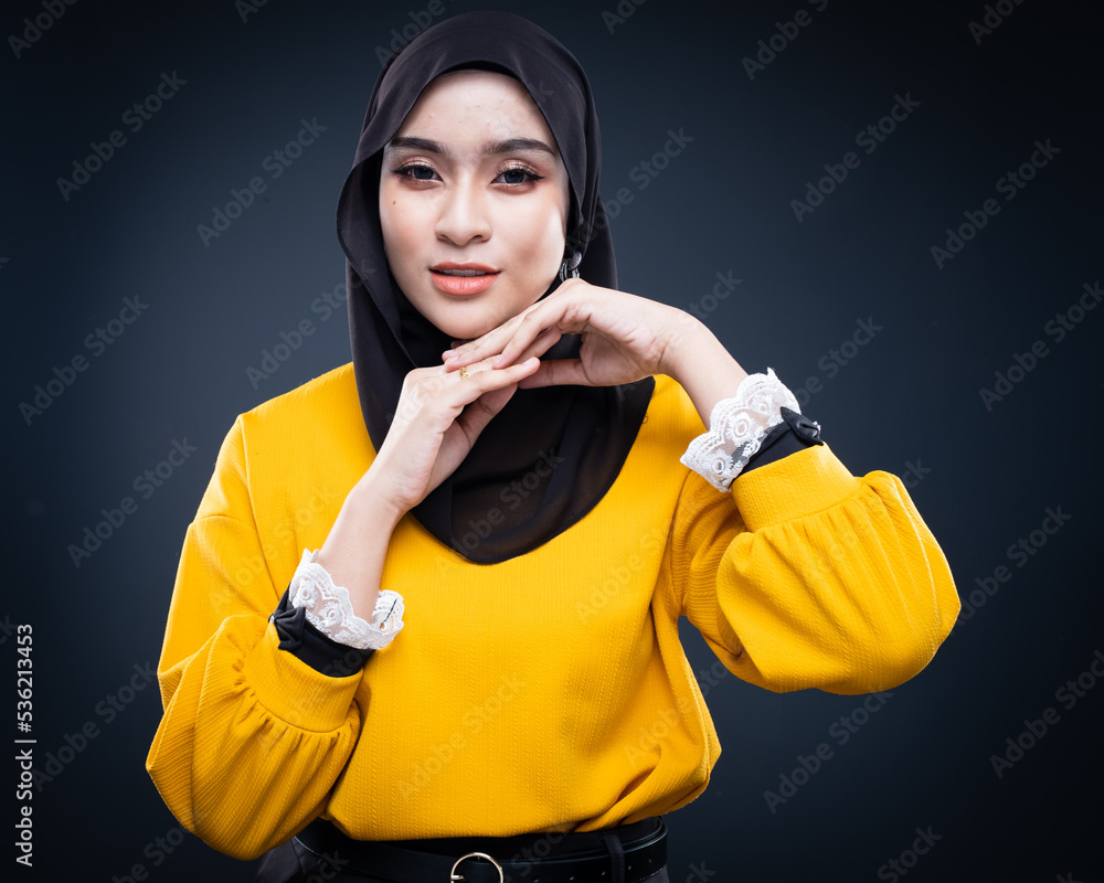 Confident Muslim woman wearing hijab poses strongly and confidently. Women empowerment and leadership concept. Isolated on dark background Confident Muslim woman wearing hijab poses strongly and confidently. Women empowerment and leadership concept. Isolated on dark background