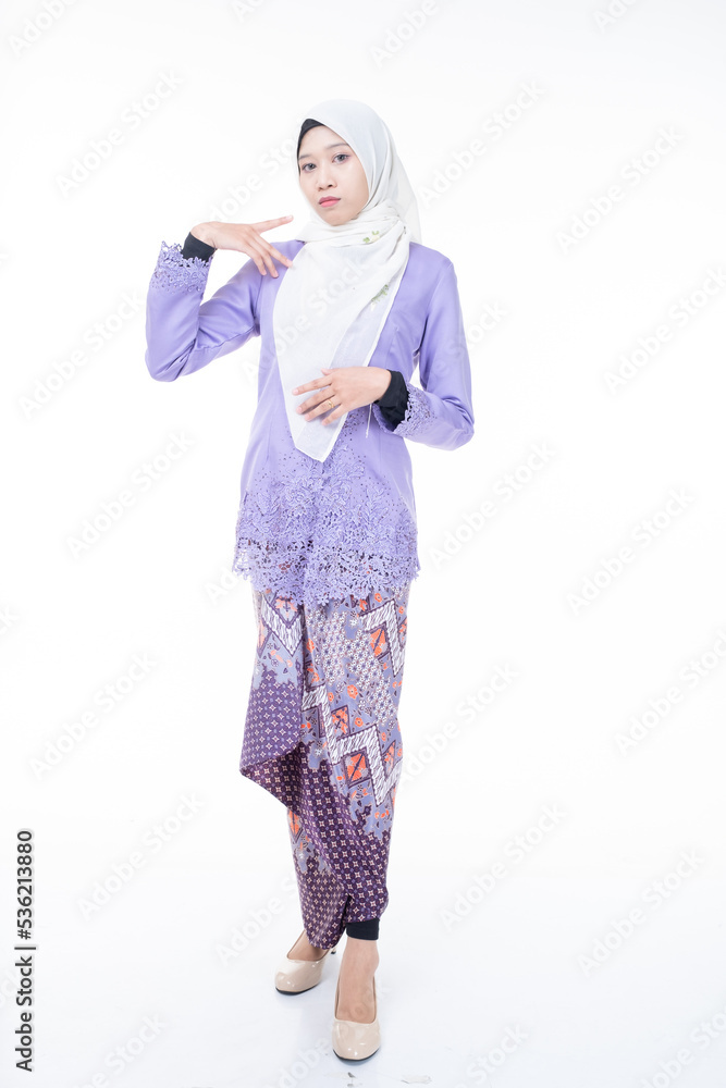 Portrait of a beautiful female model wearing hijab, a lifestyle apparel for Muslim women isolated on brown background. Idul Fitri and hijab fashion concept. Isolated on white background Portrait of a beautiful female model wearing hijab, a lifestyle apparel for Muslim women isolated on brown background. Idul Fitri and hijab fashion concept. Isolated on white background