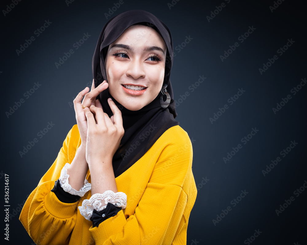 Confident Muslim woman wearing hijab poses strongly and confidently. Women empowerment and leadership concept. Isolated on dark background Confident Muslim woman wearing hijab poses strongly and confidently. Women empowerment and leadership concept. Isolated on dark background