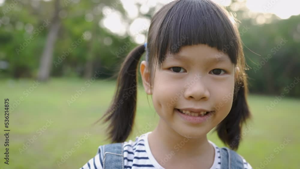 Portrait of young happy asian little girl have fun in the park. Close up smile face girl. Beautiful little girl 7 years old has lost milk teeth. Loss of milk teeth, replacement of permanent teeth. Portrait of young happy asian little girl have fun in the park. Close up smile face girl. Beautiful little girl 7 years old has lost milk teeth. Loss of milk teeth, replacement of permanent teeth.