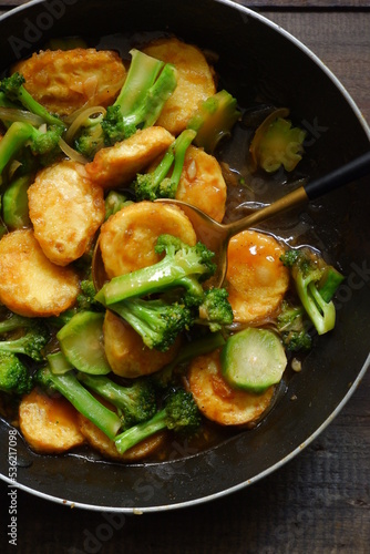  selective focus of stir fry of broccoli and tofu in a spoon 
