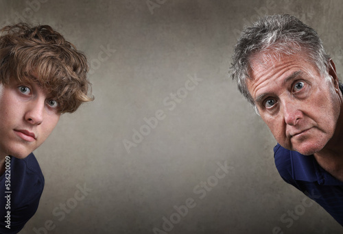 Father and son peeking around a wall