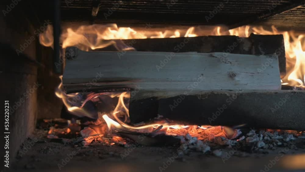 A fire burning in a stone furnace. filmed in slow motion. Only the flames are visible and bright. Stationary shot. The wood is not completely in flames. A fire burning in a stone furnace. filmed in slow motion. Only the flames are visible and bright. Stationary shot. The wood is not completely in flames.