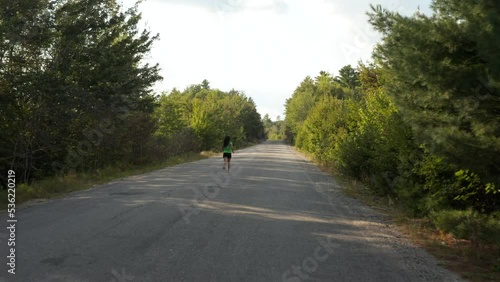 Wallpaper Mural Wide tracking shot of a young woman running the backroads of Maine, USA Torontodigital.ca