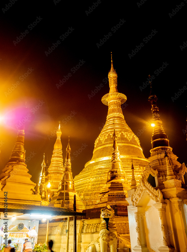 Fototapeta premium The golden pagodas and mondops are illuminated in the light of the night