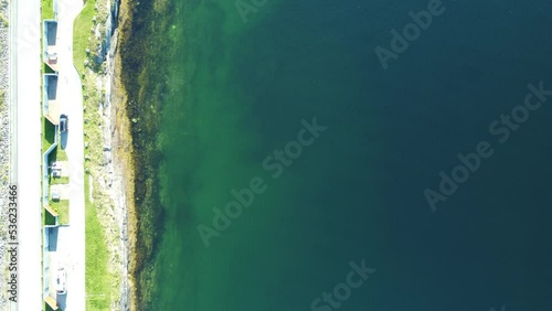 person walking in circles around a bench next to the sea and road overview photo