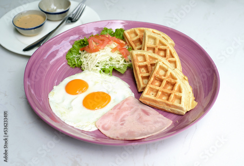 Eggs with ham and salad and belgian waffles close up