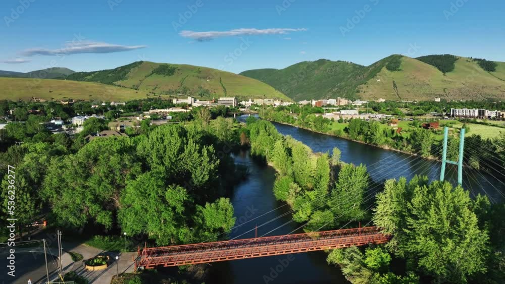 California Street Bridge Over Clark Fork River In Missoula, Montana With Mountain Landscape In Background. aerial pullback California Street Bridge Over Clark Fork River In Missoula, Montana With Mountain Landscape In Background. aerial pullback