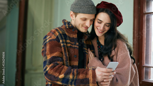 Young man and woman in love wearing stylish outfits taking selfie on smartphone camera horizontal shot  photo