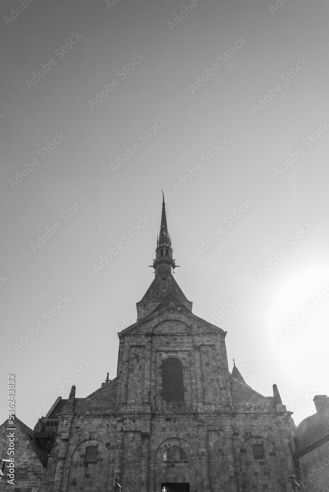 Obraz premium The facade of the abbey at the famous Mont Saint Michel, Normandy, France. Gray sky on the background. Monochromatic.