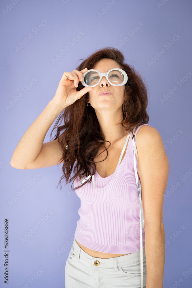 party girl with pink shirt in front of purple background with long dark hair and silver air trumpet or whistle and silver garlands party girl with pink shirt in front of purple background with long dark hair and silver air trumpet or whistle and silver garlands