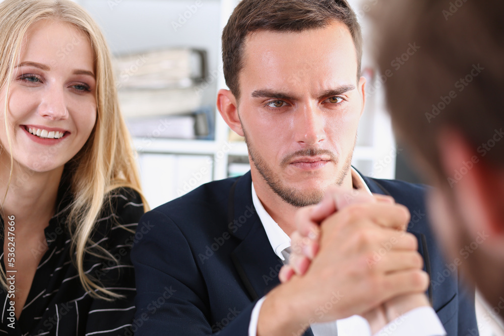 Two alpha man in suit hold hands in wrestle