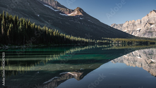 Symmetric reflection in the turquoise water of Swiftcurrent Lake in Glacier National Park, Montana photo