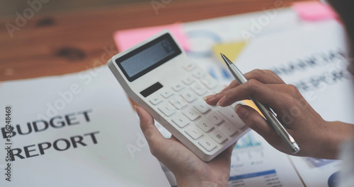 Close up Business woman using calculator for do math finance on wooden desk in office and business working background, tax, accounting, statistics and analytic research concept