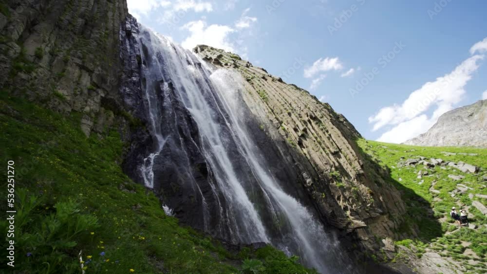 Aerial backwards beautiful waterfall cascade, alpine glacial river falls from rocks. Impressive spring nature landscape North Caucasus Kabardino-Balkaria, incredible russia scenery. Slow motion movie Aerial backwards beautiful waterfall cascade, alpine glacial river falls from rocks. Impressive spring nature landscape North Caucasus Kabardino-Balkaria, incredible russia scenery. Slow motion movie