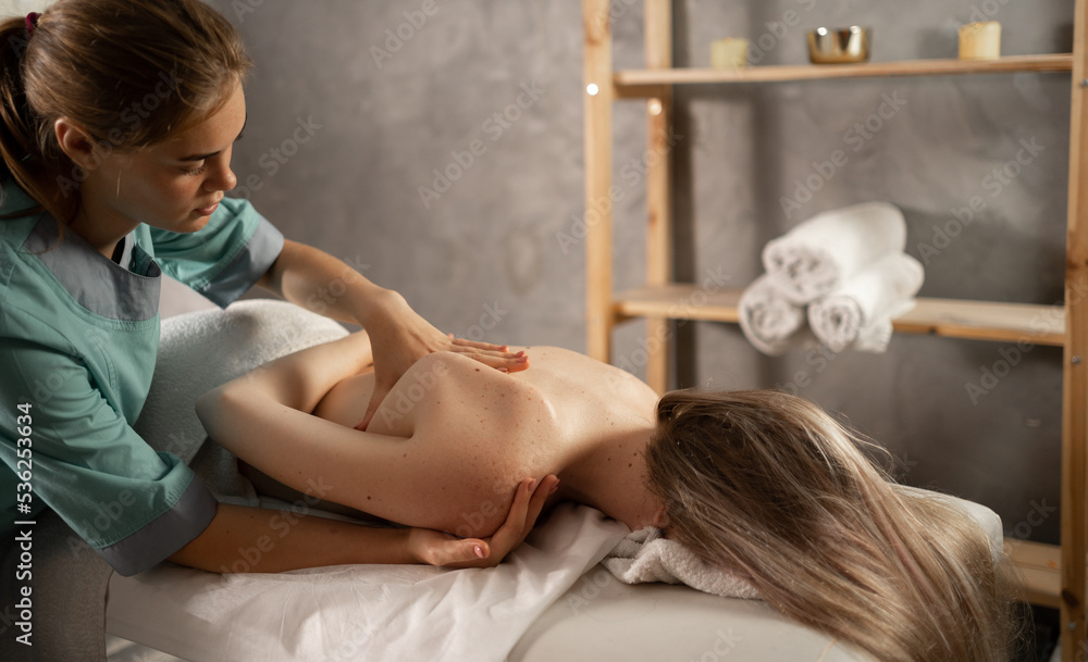 Αυτοκόλλητο Professional masseuse or manual therapist massaging young woman's shoulder, easing pain