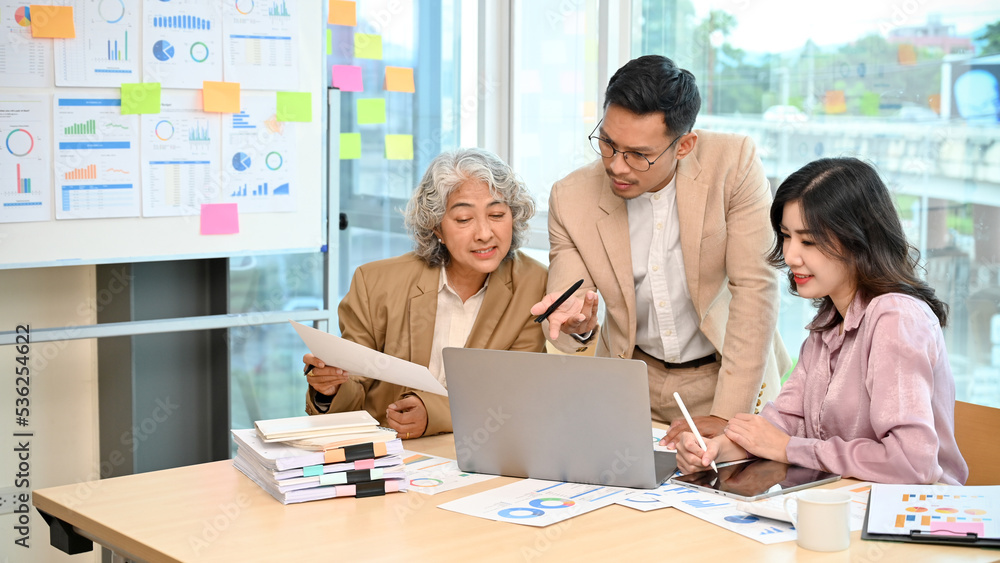 Obraz premium Smart Asian businessman analyzing financial plan with his team in the meeting.