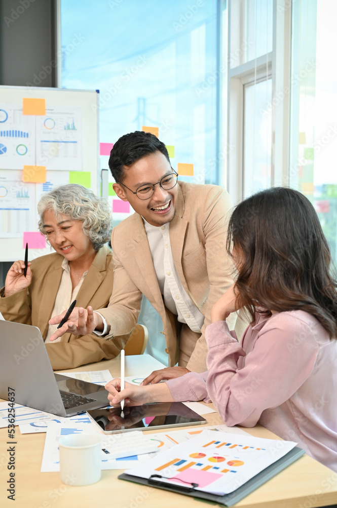 Cheerful Asian businessman discussing with a female employee during the meeting. Cheerful Asian businessman discussing with a female employee during the meeting.