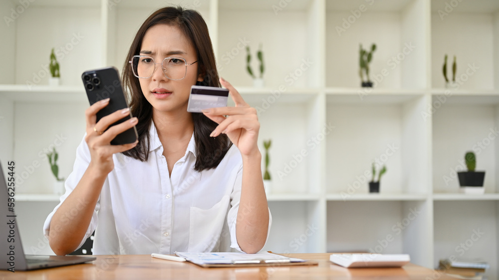 Attractive Asian woman having a problems on her mobile banking account Attractive Asian woman having a problems on her mobile banking account