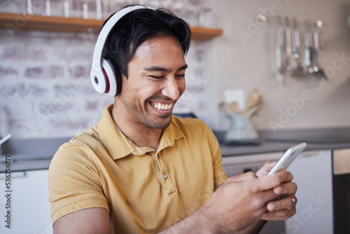 Phone, music and man on social media laughing at a funny joke on a podcast, network app or video streaming website. Smile, meme and happy Asian person sharing trendy online content to relax at home
