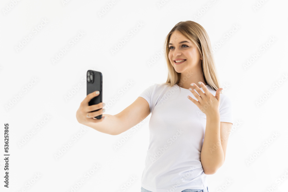 Happy woman chatting via video call and greeting with hand on a white background Happy woman chatting via video call and greeting with hand on a white background
