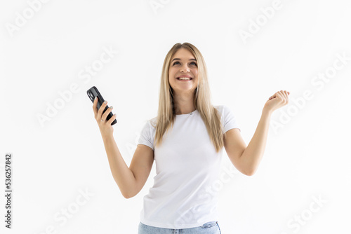 Young woman use smartphone impressed social media like feedback win raise fists scream yes over white grey background