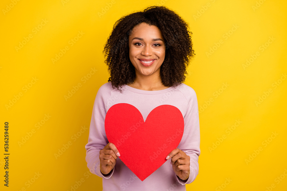 Photo of young cheerful woman hold paper heart present cupid feelings isolated over yellow color background Photo of young cheerful woman hold paper heart present cupid feelings isolated over yellow color background
