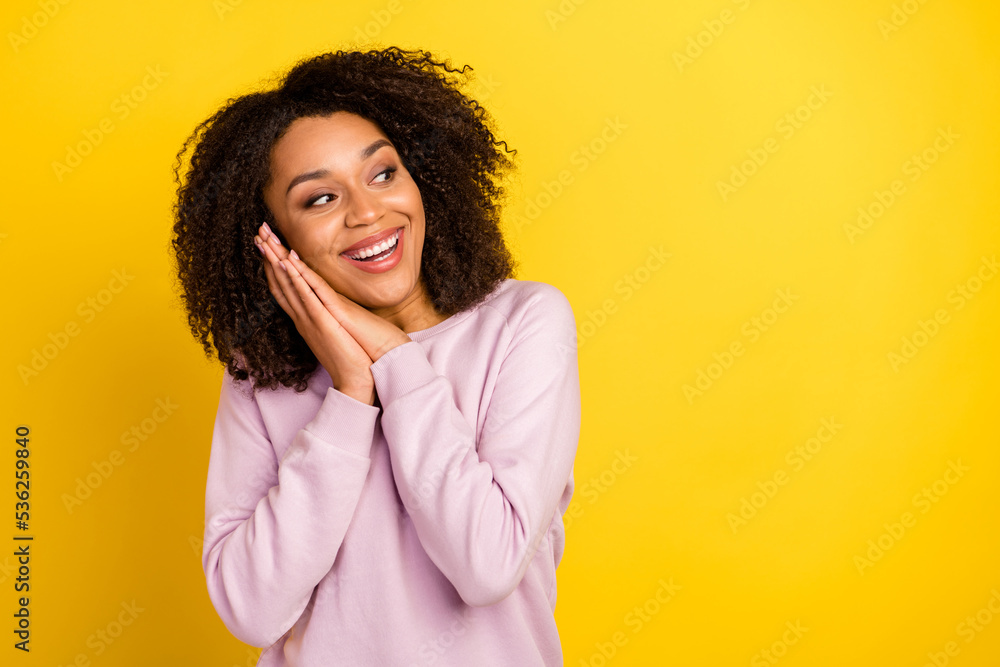 Photo of young lovely woman hands touch cheeks curious look empty space isolated over yellow color background Photo of young lovely woman hands touch cheeks curious look empty space isolated over yellow color background