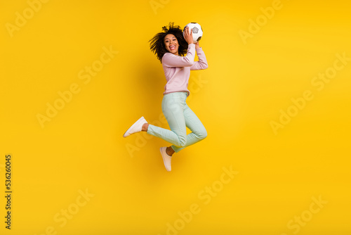 Fototapeta Naklejka Na Ścianę i Meble -  Full size profile side photo of young lady jump up energetic catch ball isolated over yellow color background