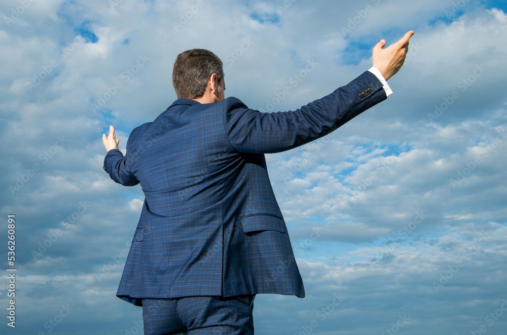 Professional man back view sky background. Man spreading arms wide open. Man in suit outdoors Professional man back view sky background. Man spreading arms wide open. Man in suit outdoors