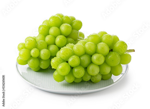 Shine Muscat with water droplets placed on a plate against a white background. photo