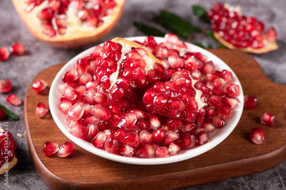 ripe pomegranate seeds in plate on table ripe pomegranate seeds in plate on table