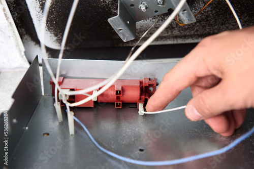 Handyman repairs or maintains a gas stove photo