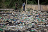 Men looks on piles of trash in a public landfill site located in Sao Paulo, Brazil.