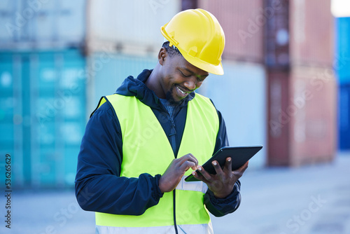 Logistics, tablet and black man doing container shipping at an industrial cargo, shipping and freight supply chain. Delivery manager or stock service worker working at distribution trade port outdoor