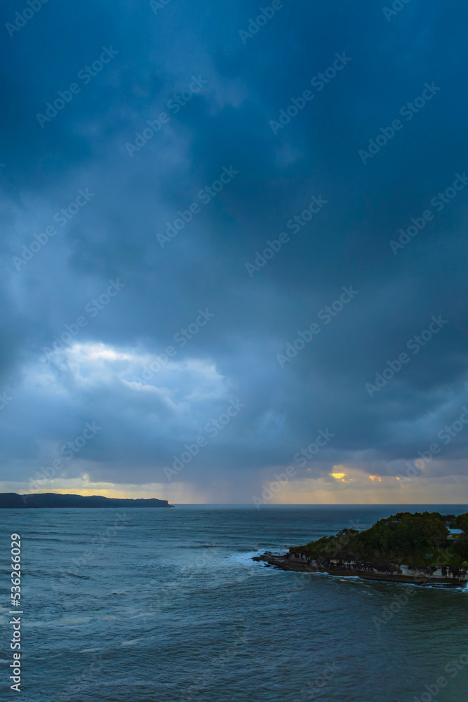 Sunrise seascape with overcast sky and rain clouds