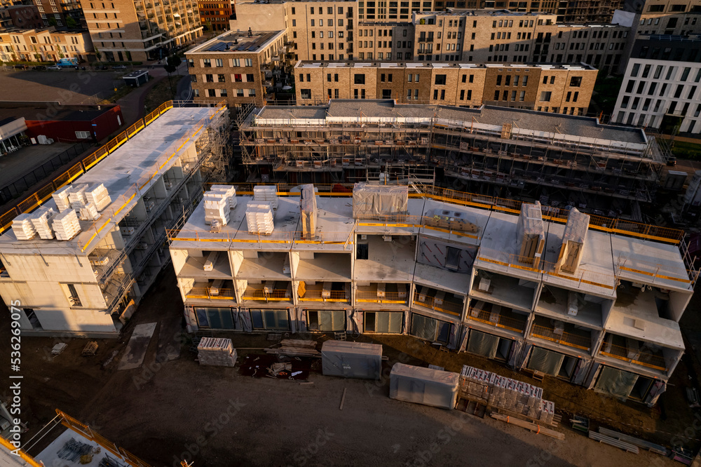 Aerial view of real estate project PUUR21 housing construction site part of urban development plan in initial building phase at sunset. Engineering architecture