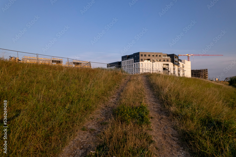 Trail leading to Kade Noord apartment building complex at the edge of the river IJssel floodplains with red construction crane behind Trail leading to Kade Noord apartment building complex at the edge of the river IJssel floodplains with red construction crane behind