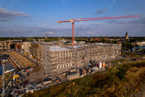 Aerial view of scaffolding luxury Kade Zuid apartment complex construction at riverbank of river IJssel between train tracks and recreational port.  © Maarten Zeehandelaar