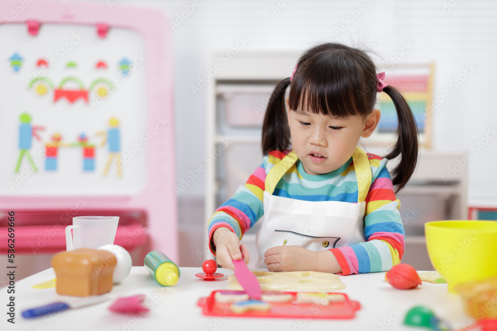 Fototapeta premium young girl pretend playing food preparing at home