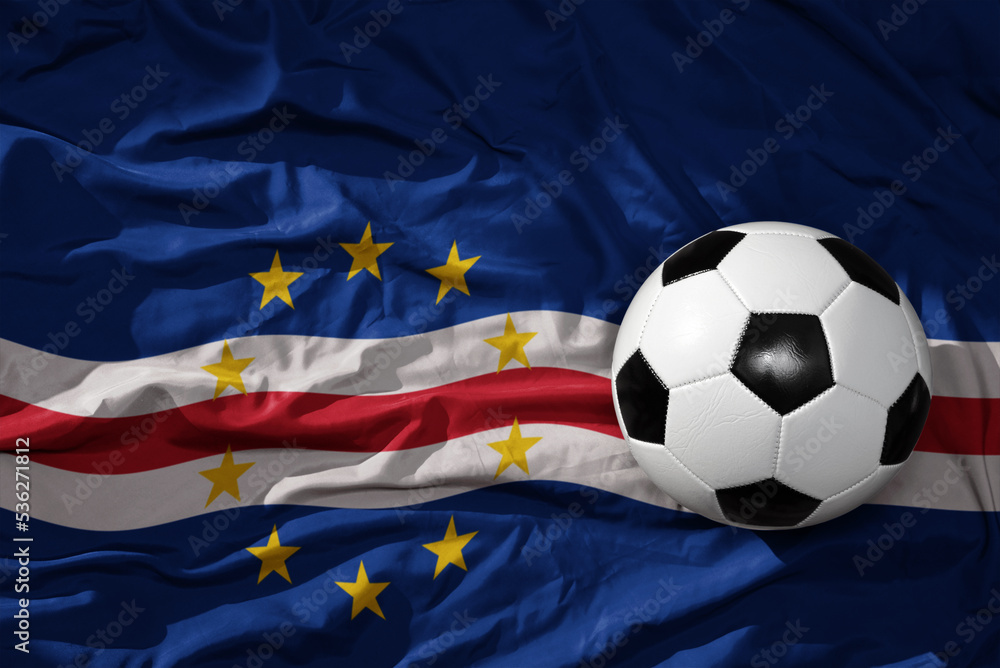 Fototapeta premium vintage football ball on the waveing national flag of cape verde background. 3D illustration