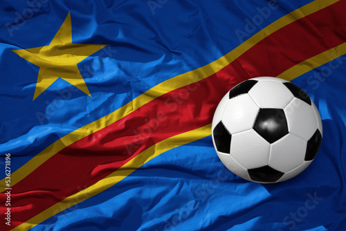 vintage football ball on the waveing national flag of democratic republic of the congo background. 3D illustration