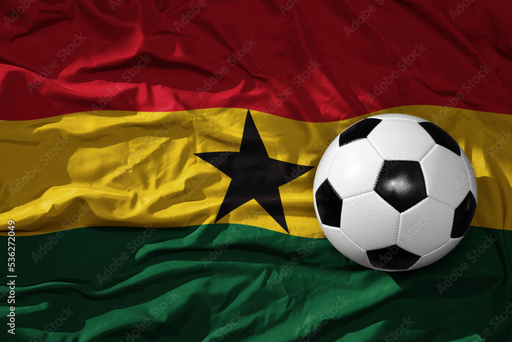 Fototapeta premium vintage football ball on the waveing national flag of ghana background. 3D illustration