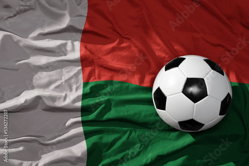vintage football ball on the waveing national flag of madagascar background. 3D illustration